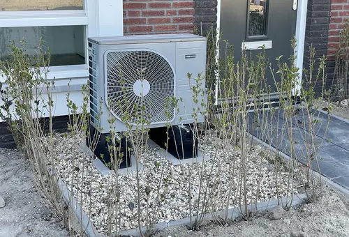 Wärmepumpe Eine vor einem Gebäude installierte Wärmepumpe