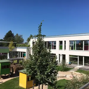 Gebäude mit Garten Blick vom Garten mit Spielgeräten auf das Gebäude