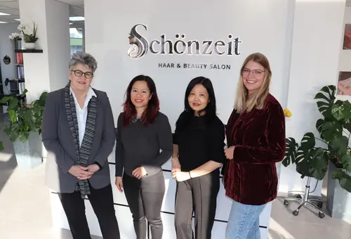 (c) Stadt Oberasbach Erste Bürgermeisterin Birgit Huber, Schönzeit-Inhaberin Truong Thi Phuong Thao, Friseurmeisterin Thi Phuong Loan Nguyen und Michaela Heckel, Wirtschaftsförderung Stadt Oberasbach stehen vor dem Empfangstresen im neuen Salon.